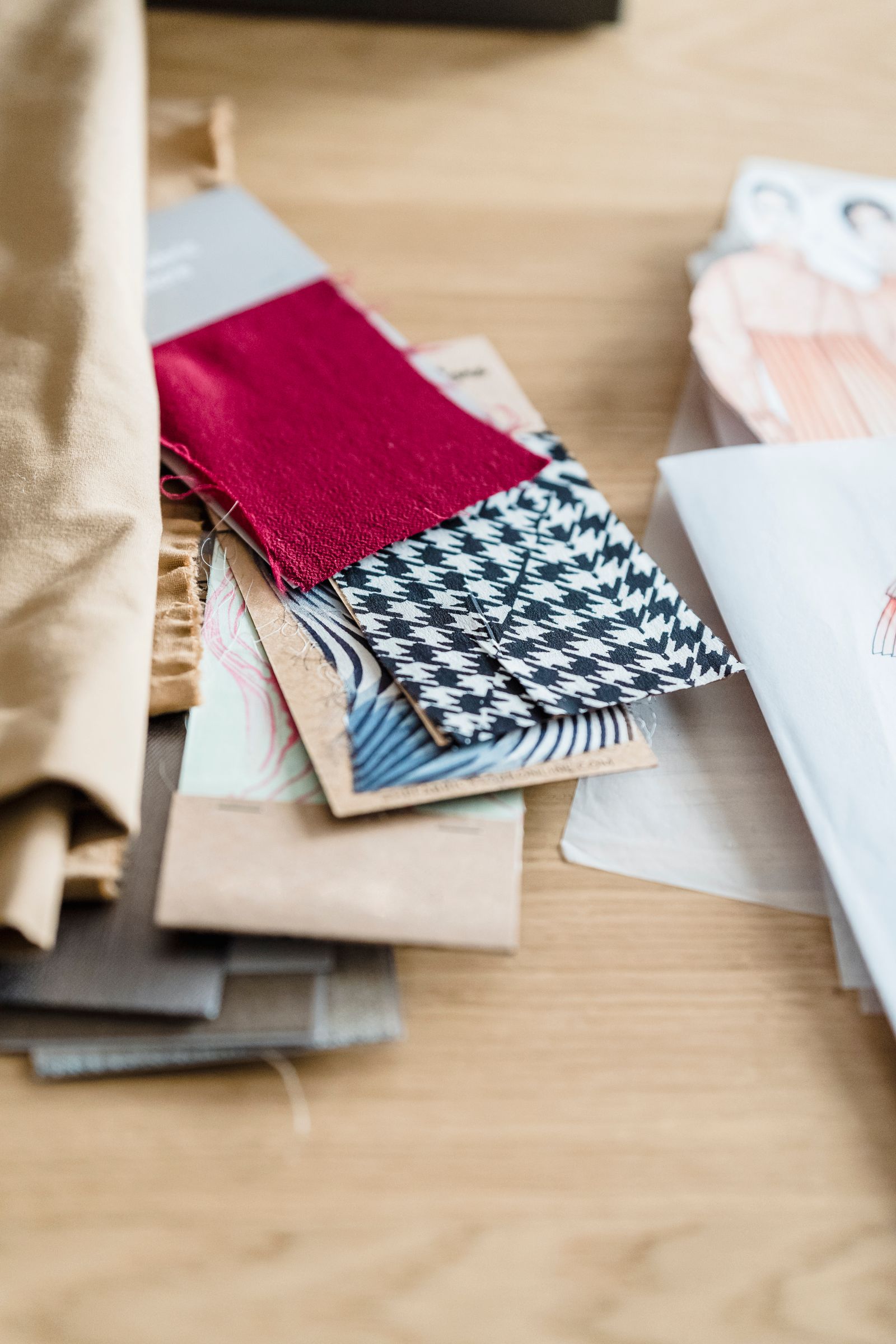 Assorted fabric swatches and sketches arranged on a worktable